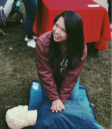 Girl giving a CPR to a doll