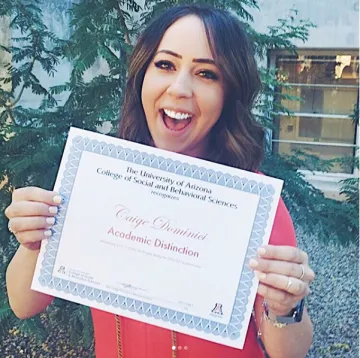 girl showing off her academic distinction paper