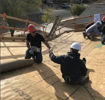 two construction workers bumping their fists