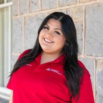 Perla posing in a red polo shirt